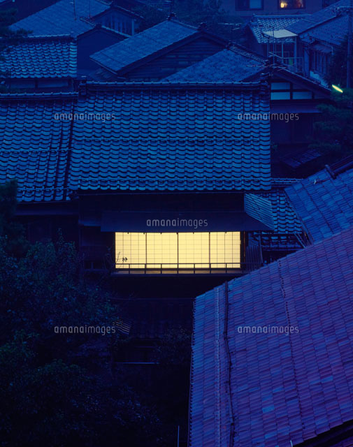 暮時瓦屋根の下で障子越しに灯りのある家 の写真素材 イラスト素材 アマナイメージズ