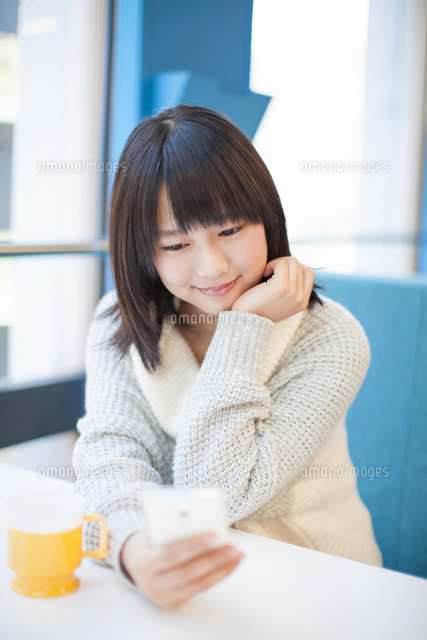 スマホを見る女の子 の写真素材 イラスト素材 アマナイメージズ