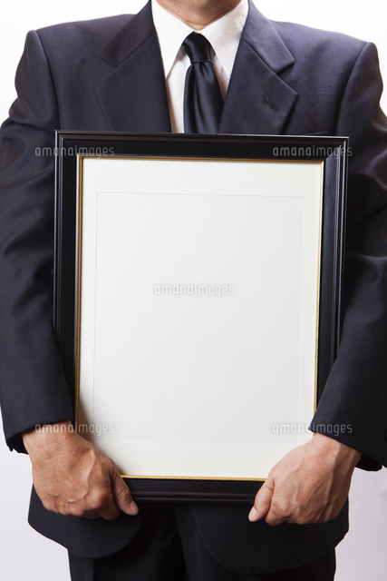 遺影を持つ喪主の男性 の写真素材 イラスト素材 アマナイメージズ