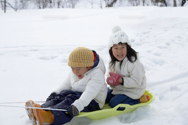 雪の中でそり遊びをする子ども達 の写真素材 イラスト素材 アマナイメージズ