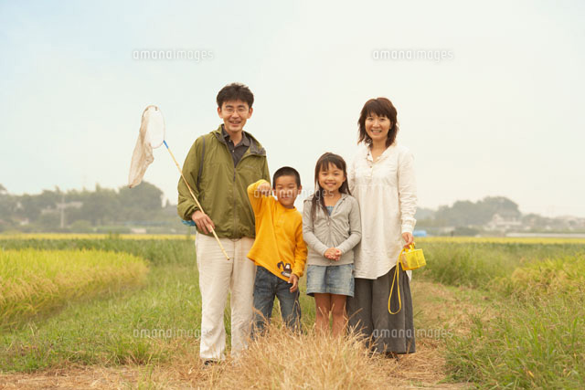 田んぼに立つ家族のポートレート[10132104778]の写真・イラスト素材
