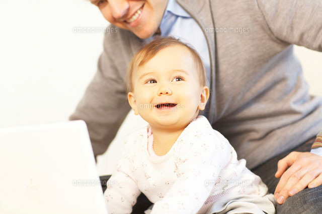 床の上でノートパソコンの画面を見る赤ちゃんと父親 の写真素材 イラスト素材 アマナイメージズ