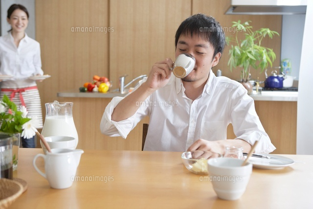朝食を運ぶ女性とコーヒーを飲む男性の夫婦 の写真素材 イラスト素材 アマナイメージズ