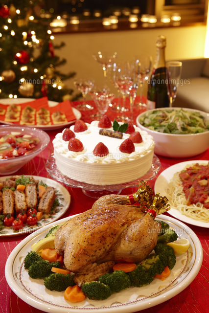 パーティでテーブル並ぶクリスマスディナーと鶏の丸焼きやケーキ の写真素材 イラスト素材 アマナイメージズ