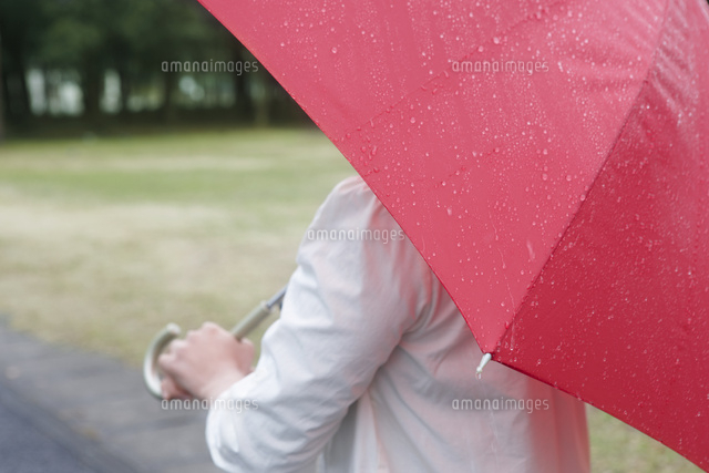 雨の日に赤い傘をさす女性 の写真素材 イラスト素材 アマナイメージズ