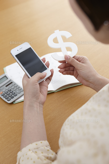 携帯電話を持って検索する女性の手とドルのお金マーク の写真素材 イラスト素材 アマナイメージズ 携帯電話を持って検索する女性の手とドルのお金マーク の写真素材 イラスト素材 アマナイメージズ