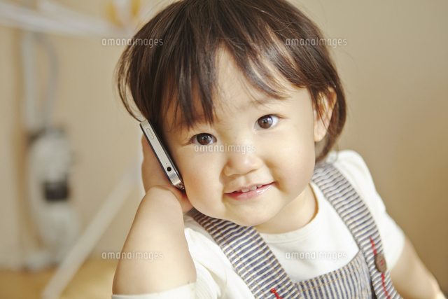 携帯電話で電話をする女の子 の写真素材 イラスト素材 アマナイメージズ