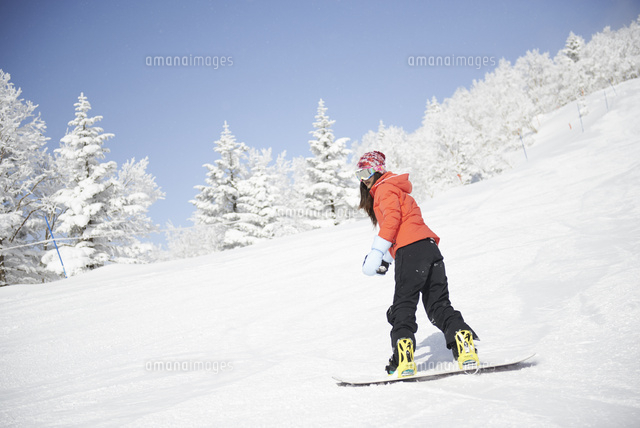 銀世界の雪山でスノーボードをする女性 の写真素材 イラスト素材 アマナイメージズ