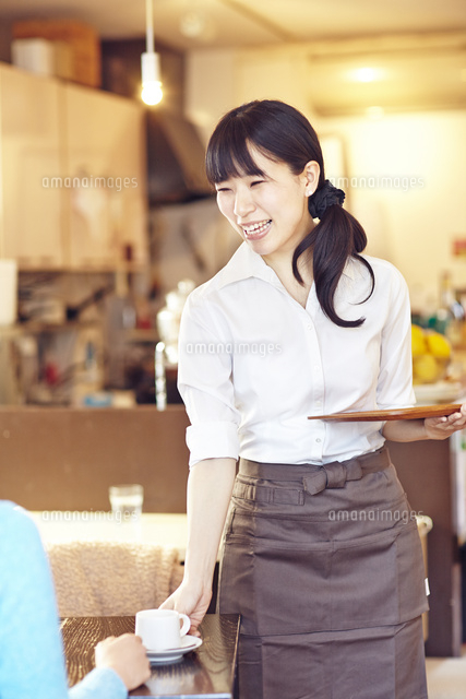 カフェにて接客をして働く女性 の写真素材 イラスト素材 アマナイメージズ