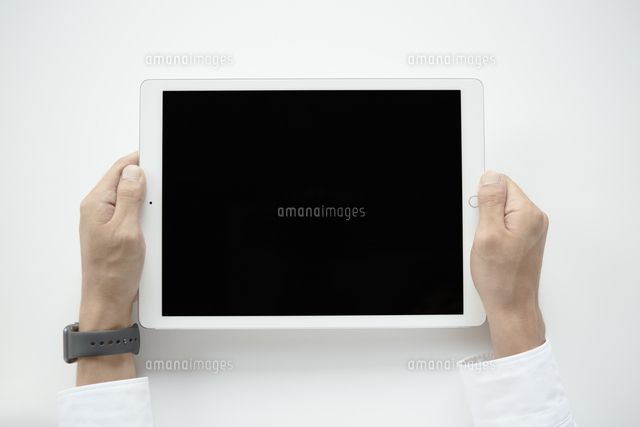 タブレットpcを持つ手元 の写真素材 イラスト素材 アマナイメージズ