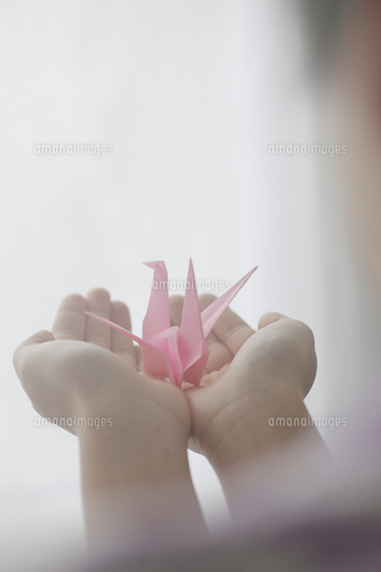 女の子の手と折り鶴 の写真素材 イラスト素材 アマナイメージズ