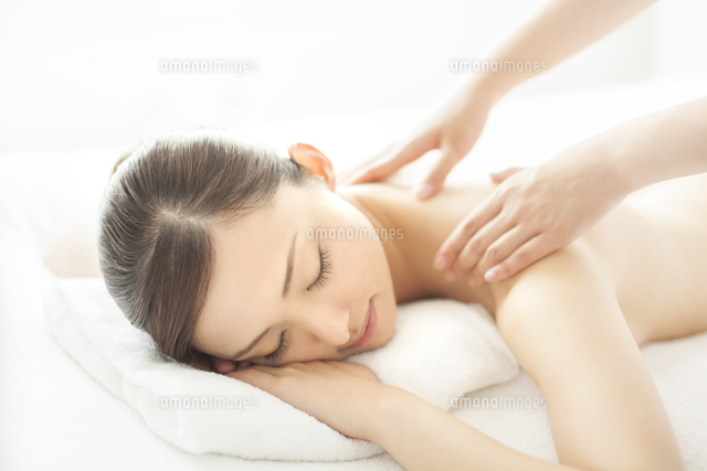 ベッドにうつ伏せで肩にマッサージを受ける女性 の写真素材 イラスト素材 アマナイメージズ