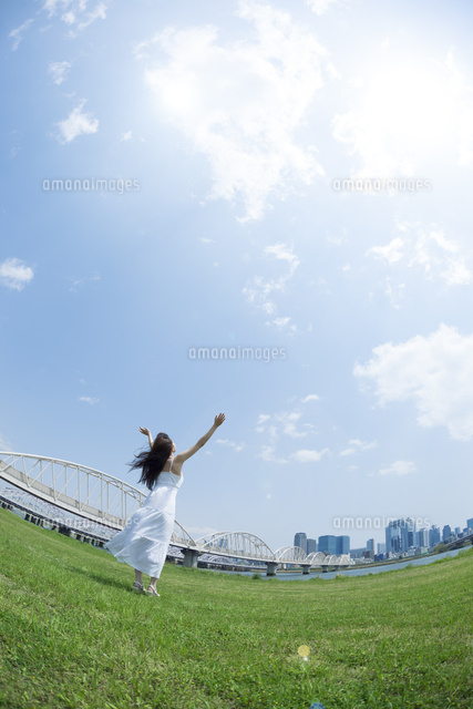 都会の青空の下で空を見上げる女性 の写真素材 イラスト素材 アマナイメージズ