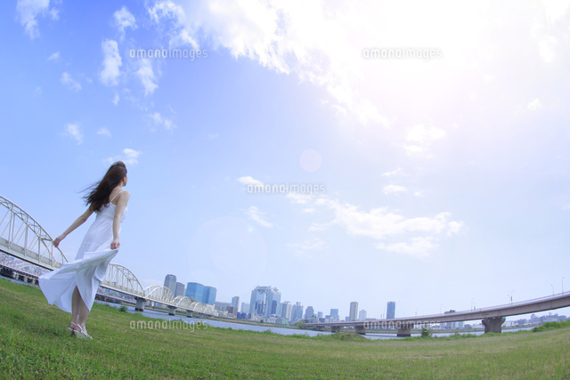 都会の青空の下で空を見上げる女性 の写真素材 イラスト素材 アマナイメージズ
