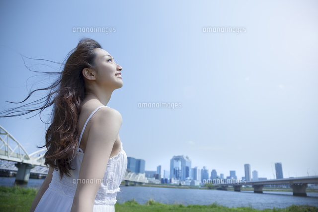 都会の青空の下で空を見上げる女性 の写真素材 イラスト素材 アマナイメージズ