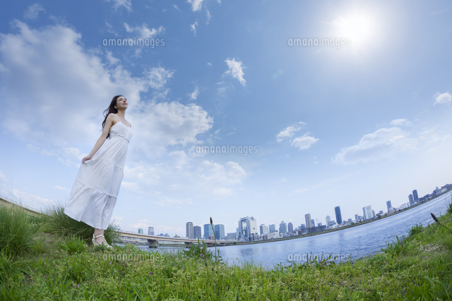 都会の青空の下で空を見上げる女性 の写真素材 イラスト素材 アマナイメージズ