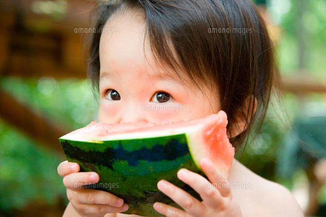 スイカを食べる小学生の男の子[10154000526]の写真・イラスト素材
