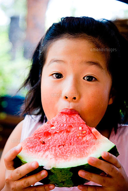 スイカを食べる小学生の男の子[10154000526]の写真・イラスト素材