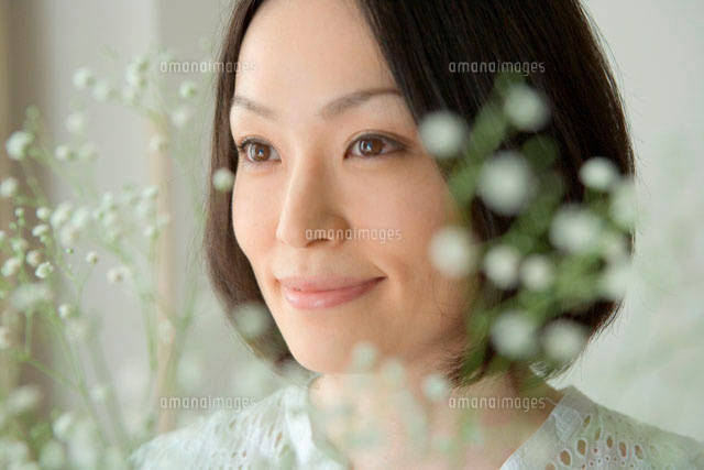 笑顔の30代女性の顔アップとかすみ草 の写真素材 イラスト素材 アマナイメージズ
