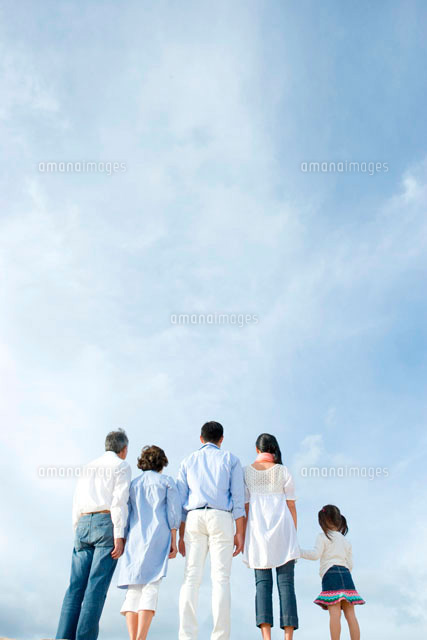青空の下に立つ家族5人の後姿 の写真素材 イラスト素材 アマナイメージズ