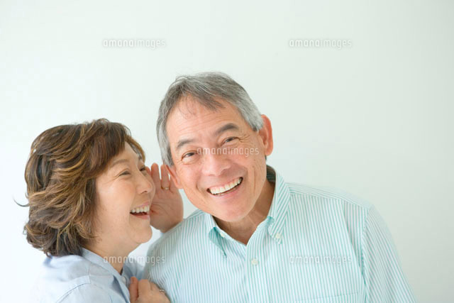 笑顔で耳打ちするシニア夫婦 の写真素材 イラスト素材 アマナイメージズ