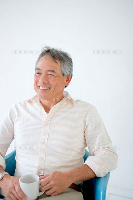 椅子に座りコーヒーカップを手に持つ60代男性 の写真素材 イラスト素材 アマナイメージズ