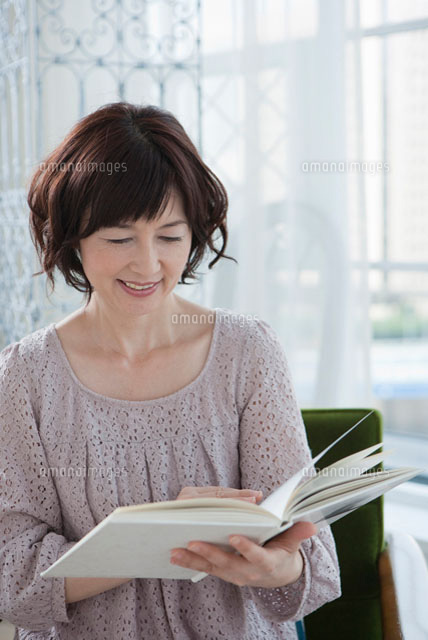 本を読む40代女性 の写真素材 イラスト素材 アマナイメージズ