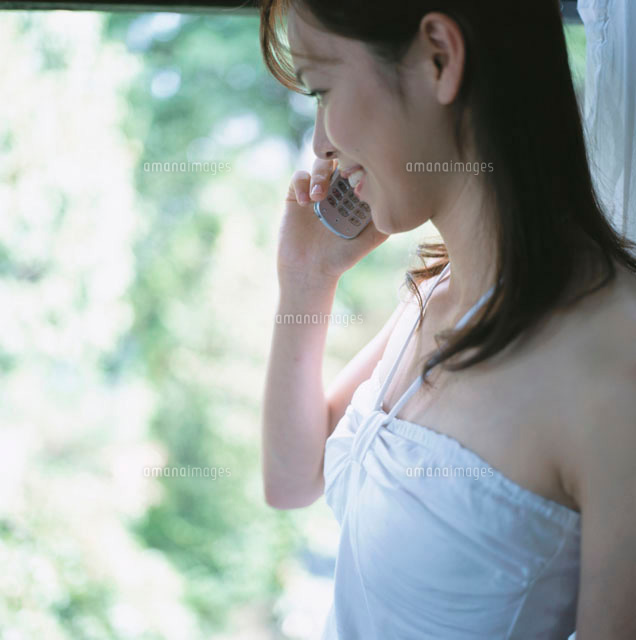 携帯電話をかける日本人女性の横顔 の写真素材 イラスト素材 アマナイメージズ