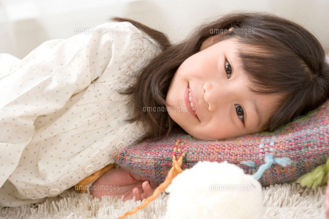 クッションに横になる5歳の女の子 の写真素材 イラスト素材 アマナイメージズ