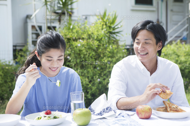 芝生の庭で食事をする代男女 の写真素材 イラスト素材 アマナイメージズ