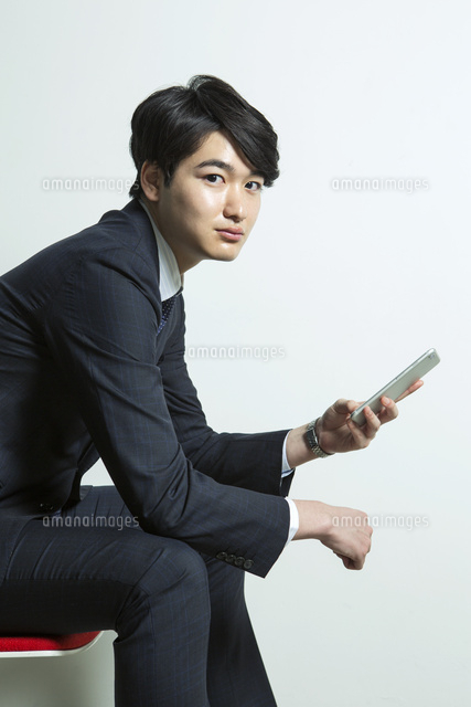 スマホを見るスーツ姿の代男性 の写真素材 イラスト素材 アマナイメージズ