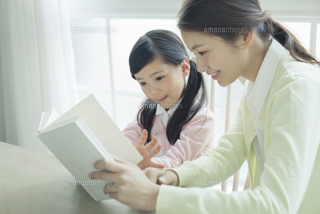 本を読む笑顔の親子 の写真素材 イラスト素材 アマナイメージズ