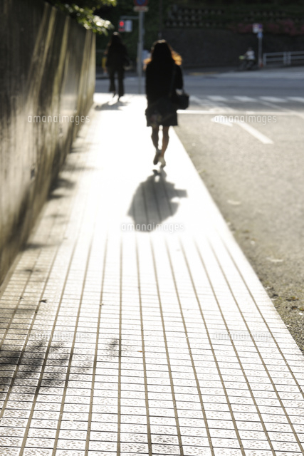 逆光の石畳の歩道と歩行者 の写真素材 イラスト素材 アマナイメージズ