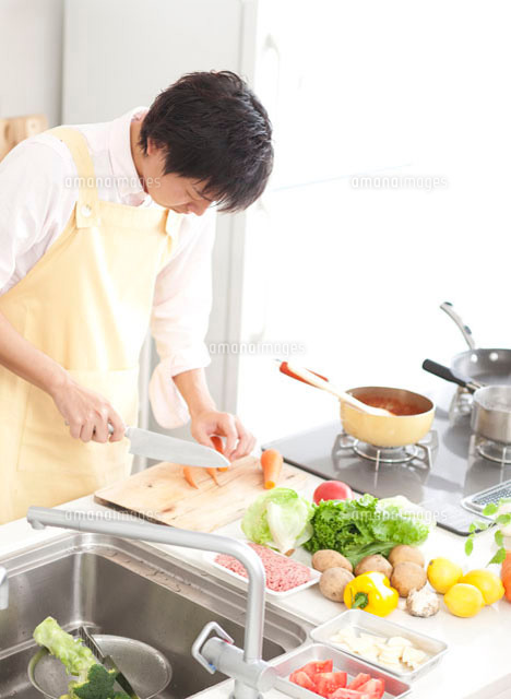 キッチンで野菜を切る若い男性 の写真素材 イラスト素材 アマナイメージズ