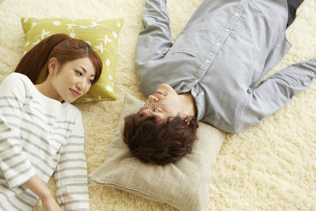 カーペットに横になる男女を上から撮影 の写真素材 イラスト素材 アマナイメージズ