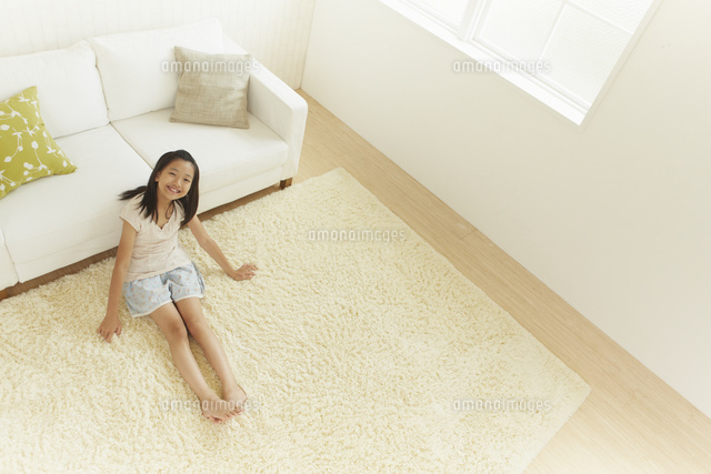 ソファーの前のカーペットに座る女の子を上から撮影 の写真素材 イラスト素材 アマナイメージズ