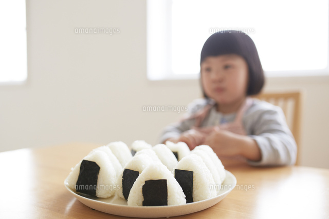 おにぎりを見つめる女の子 の写真素材 イラスト素材 アマナイメージズ