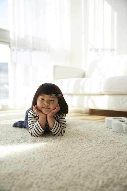カーペットに寝転ぶ女の子 の写真素材 イラスト素材 アマナイメージズ