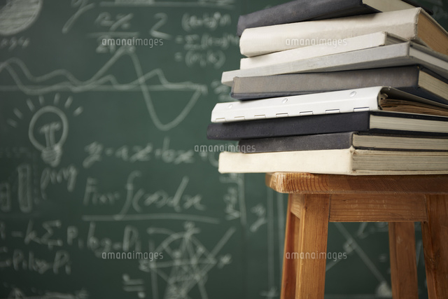 黒板の前で椅子の上に積み重ねた本 の写真素材 イラスト素材 アマナイメージズ