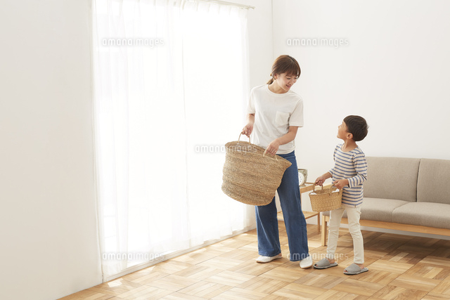 洗濯物が入ったカゴを運ぶ親子 の写真素材 イラスト素材 アマナイメージズ