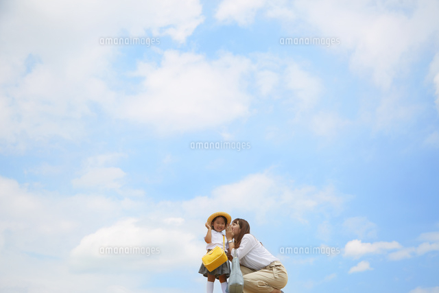 青空を背景に幼稚園児の女の子に話しかけるお母さん の写真素材 イラスト素材 アマナイメージズ