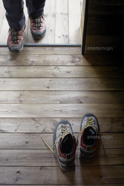 山小屋の入り口付近の床に置かれたトレッキングシューズと小屋に入る人 の写真素材 イラスト素材 アマナイメージズ