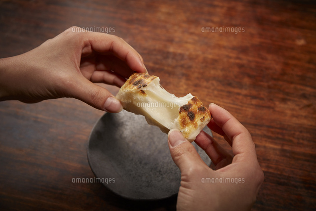 皿の上で餅を割って伸ばしている手 の写真素材 イラスト素材 アマナイメージズ