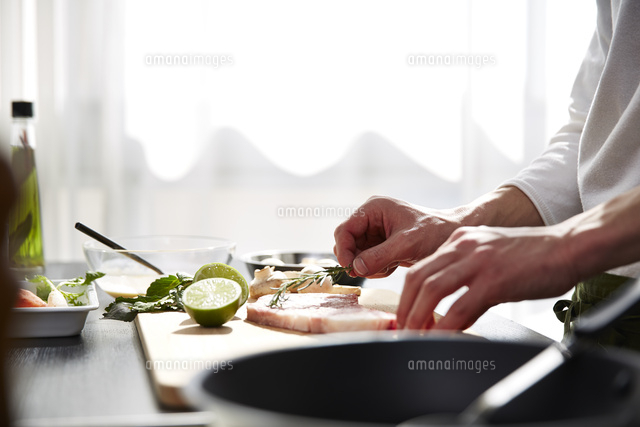 生肉に下味をつける男性の手元 の写真素材 イラスト素材 アマナイメージズ