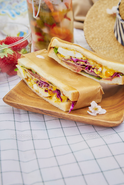 白い布の上のサンドイッチとピクルスと苺など の写真素材 イラスト素材 アマナイメージズ