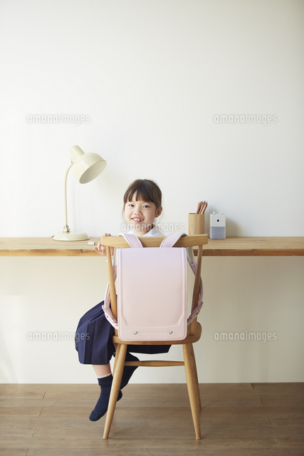 勉強スペースで振り向いて笑う小学生の女の子 の写真素材 イラスト素材 アマナイメージズ