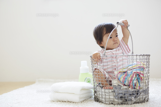 洗濯カゴの中に洗濯物と一緒に入っている赤ちゃん の写真素材 イラスト素材 アマナイメージズ