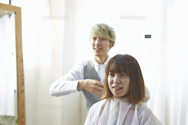 客と会話しながら髪を切る美容師 の写真素材 イラスト素材 アマナイメージズ