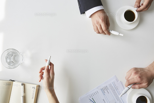 電子タバコを持ったスーツの男性ふたりと女性の手元 の写真素材 イラスト素材 アマナイメージズ