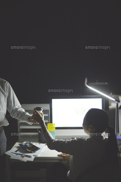 残業をする女性と差し入れをする男性 の写真素材 イラスト素材 アマナイメージズ